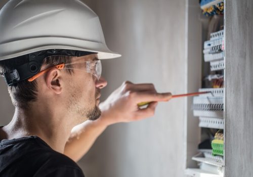 man-electrical-technician-working-switchboard-with-fuses-installation-connection-electrical-equipment-close-up_169016-5082