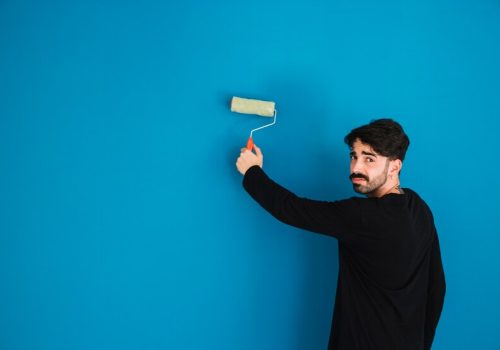 man-painting-wall-with-paint-roll_23-2147703592